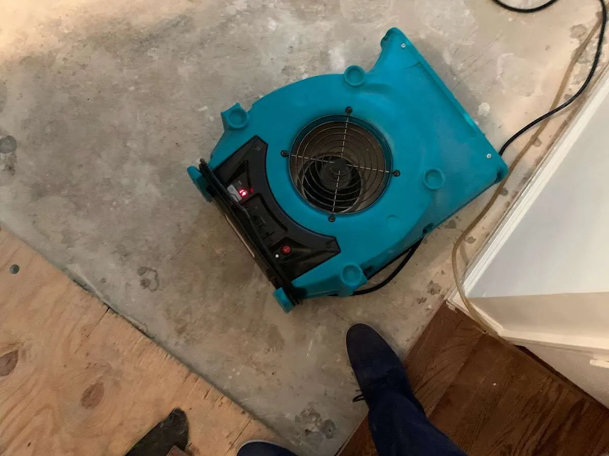 Air mover drying subfloor during Leak Detection & Repair in Baraboo